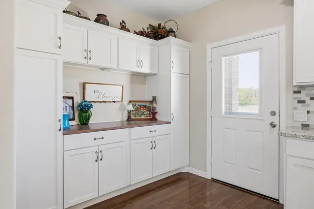 a kitchen with white cabinets and a window