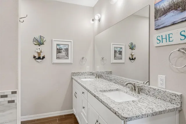 a bathroom with a granite countertop sink and a mirror
