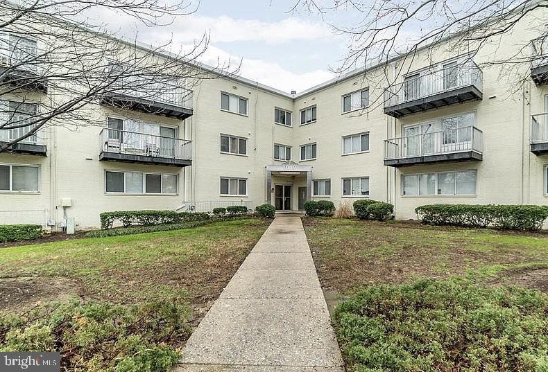 1009 Chillum Road, Unit 202 Hyattsville, MD 20782 - Photo 19 of 19 a view of a white house next to a yard with big trees