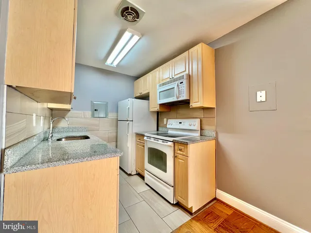 a kitchen with stainless steel appliances granite countertop a sink stove and microwave