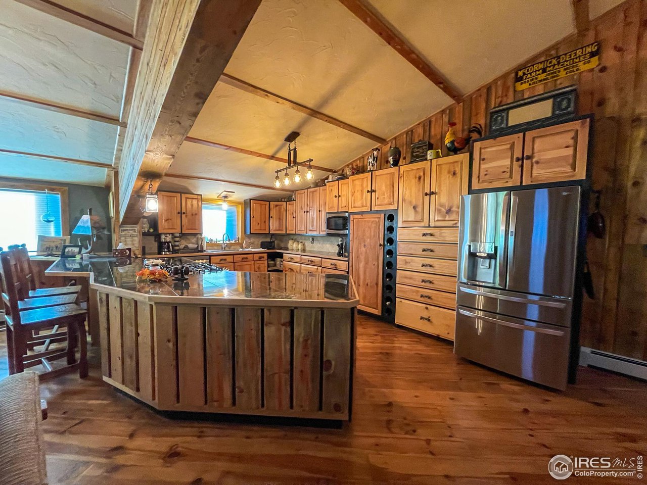 1448 Le Cook Road Allenspark, CO 80510 - Photo 12 of 39 a kitchen with stainless steel appliances kitchen island granite countertop a refrigerator a stove and a wooden floors