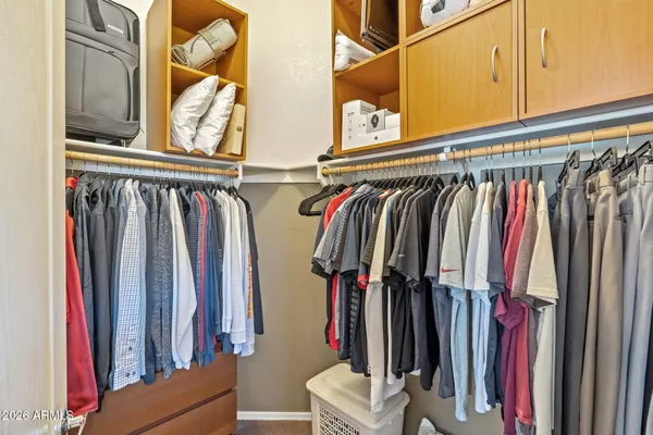 a view of walk in closet with clothes and shoes