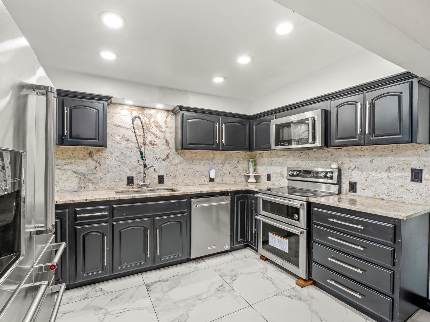 31204 Sierra Drive Exeter, CA 93221 - Photo 20 of 76 a kitchen with stainless steel appliances granite countertop a stove sink microwave and cabinets