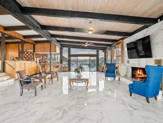 a kitchen with stainless steel appliances kitchen island granite countertop a table chairs in it and wooden floors