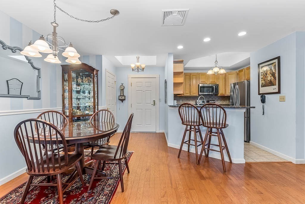 989 East Street, Unit 402 Dedham, MA 02026 - Photo 11 of 28 a view of a dining room with furniture window and wooden floor