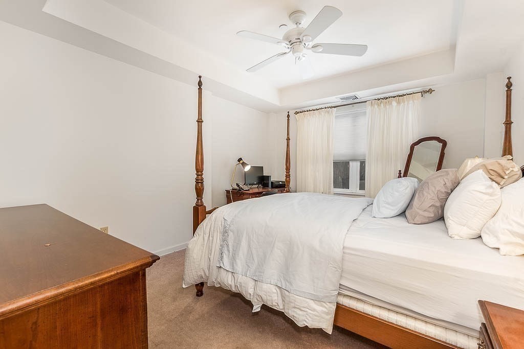 989 East Street, Unit 402 Dedham, MA 02026 - Photo 14 of 28 a bedroom with a bed and a chandelier