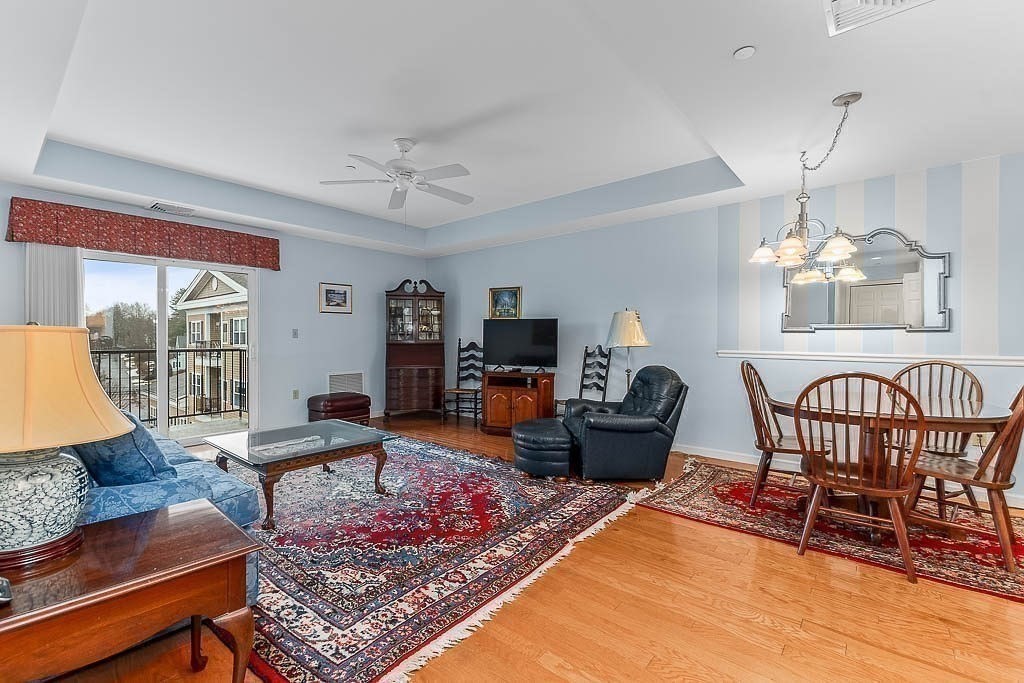 989 East Street, Unit 402 Dedham, MA 02026 - Photo 8 of 28 a living room with furniture and a chandelier