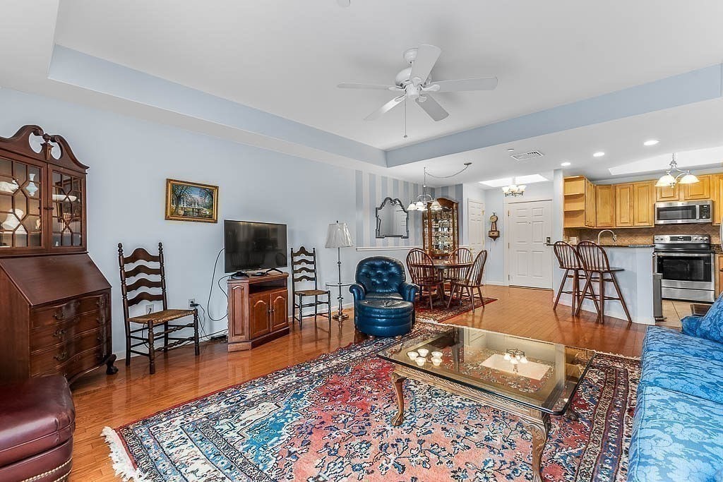 989 East Street, Unit 402 Dedham, MA 02026 - Photo 10 of 28 a living room with furniture and a flat screen tv