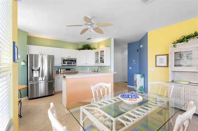 a living room with stainless steel appliances furniture and kitchen view