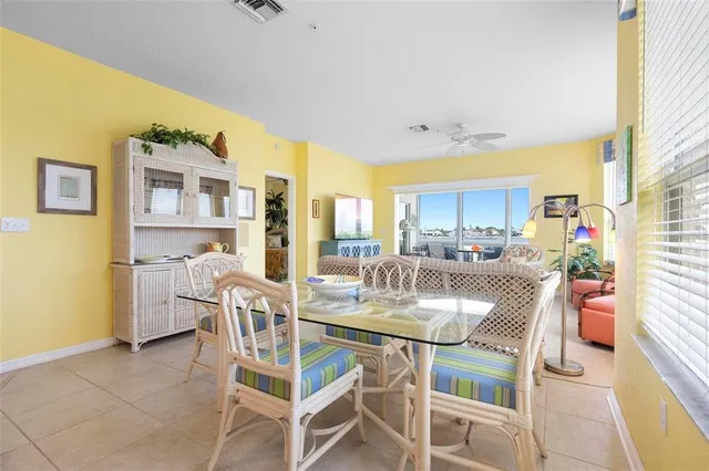 a dining room with stainless steel appliances a dining table and chairs