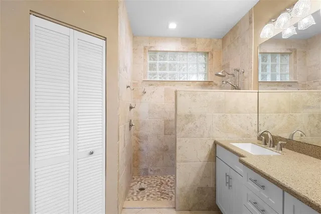a bathroom with a granite countertop sink a shower and a mirror