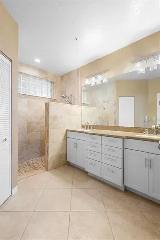 a bathroom with a granite countertop sink a mirror and a shower