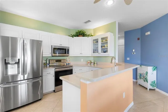 a kitchen with stainless steel appliances a refrigerator sink and microwave