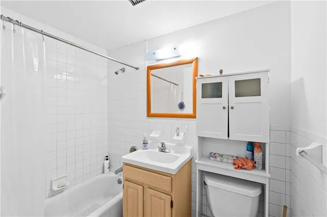 a bathroom with a sink toilet vanity and tub