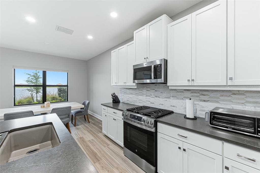 4191 Pegasus Way Naples, FL 34120 - Photo 14 of 48 a kitchen with stainless steel appliances white cabinets sink and a granite counter top