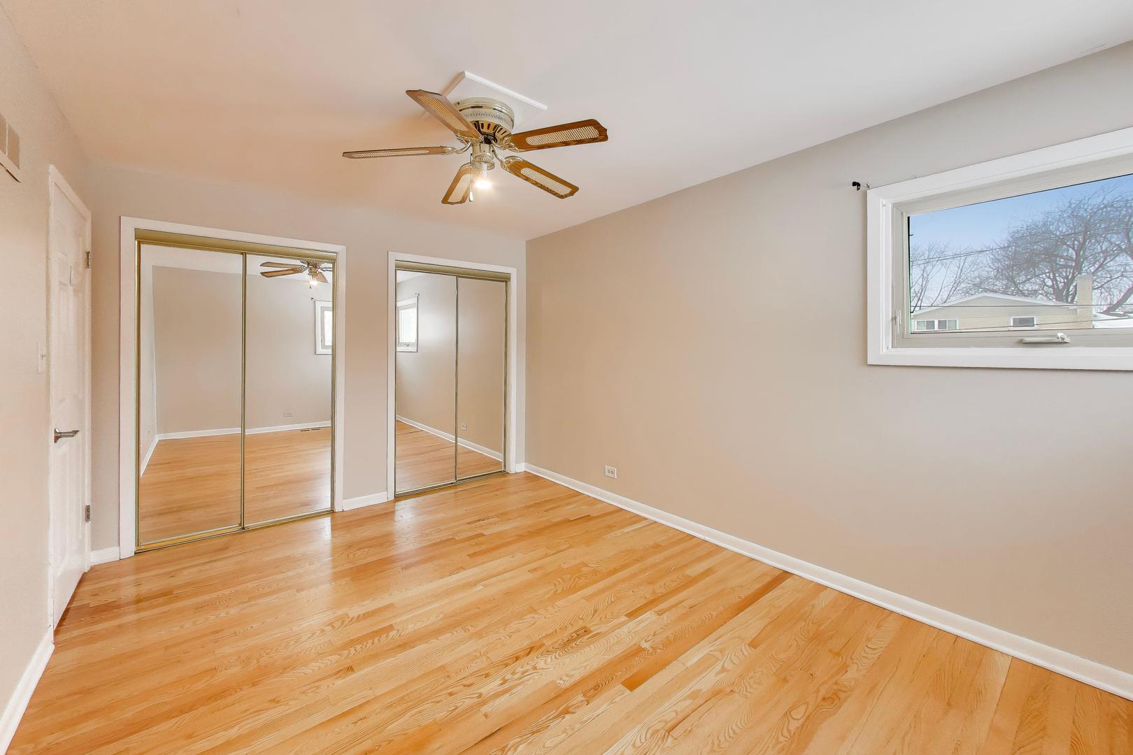 9416 Oliphant Avenue Morton Grove, IL 60053 - Photo 12 of 27 a view of an empty room with wooden floor and a fan