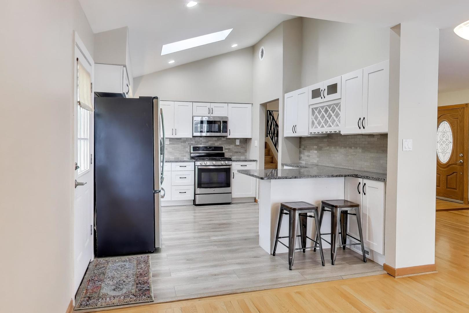 9416 Oliphant Avenue Morton Grove, IL 60053 - Photo 2 of 27 a kitchen with granite countertop a refrigerator cabinets and wooden floor