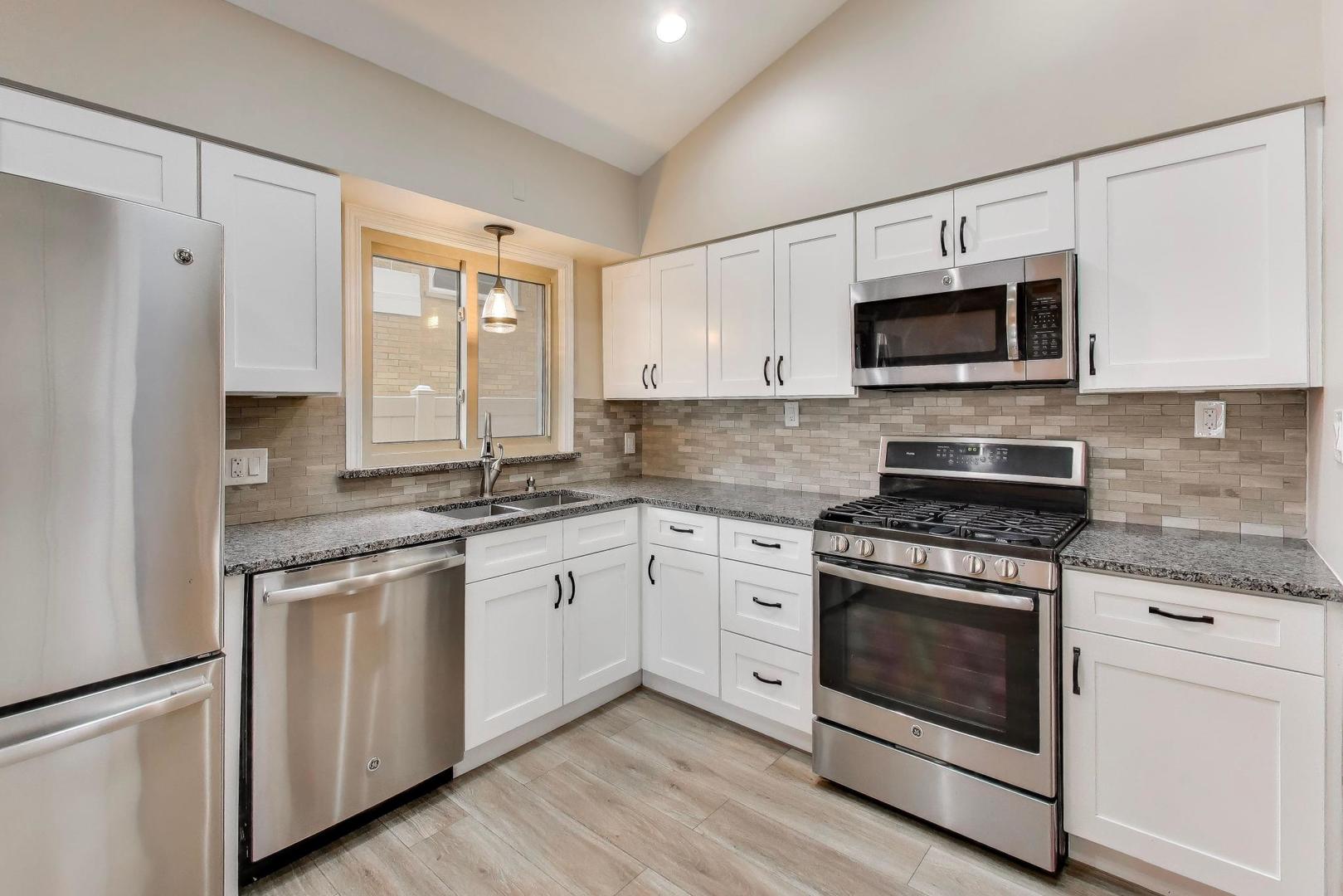 9416 Oliphant Avenue Morton Grove, IL 60053 - Photo 5 of 27 a kitchen with stainless steel appliances granite countertop white cabinets a sink a stove a refrigerator and white cabinets