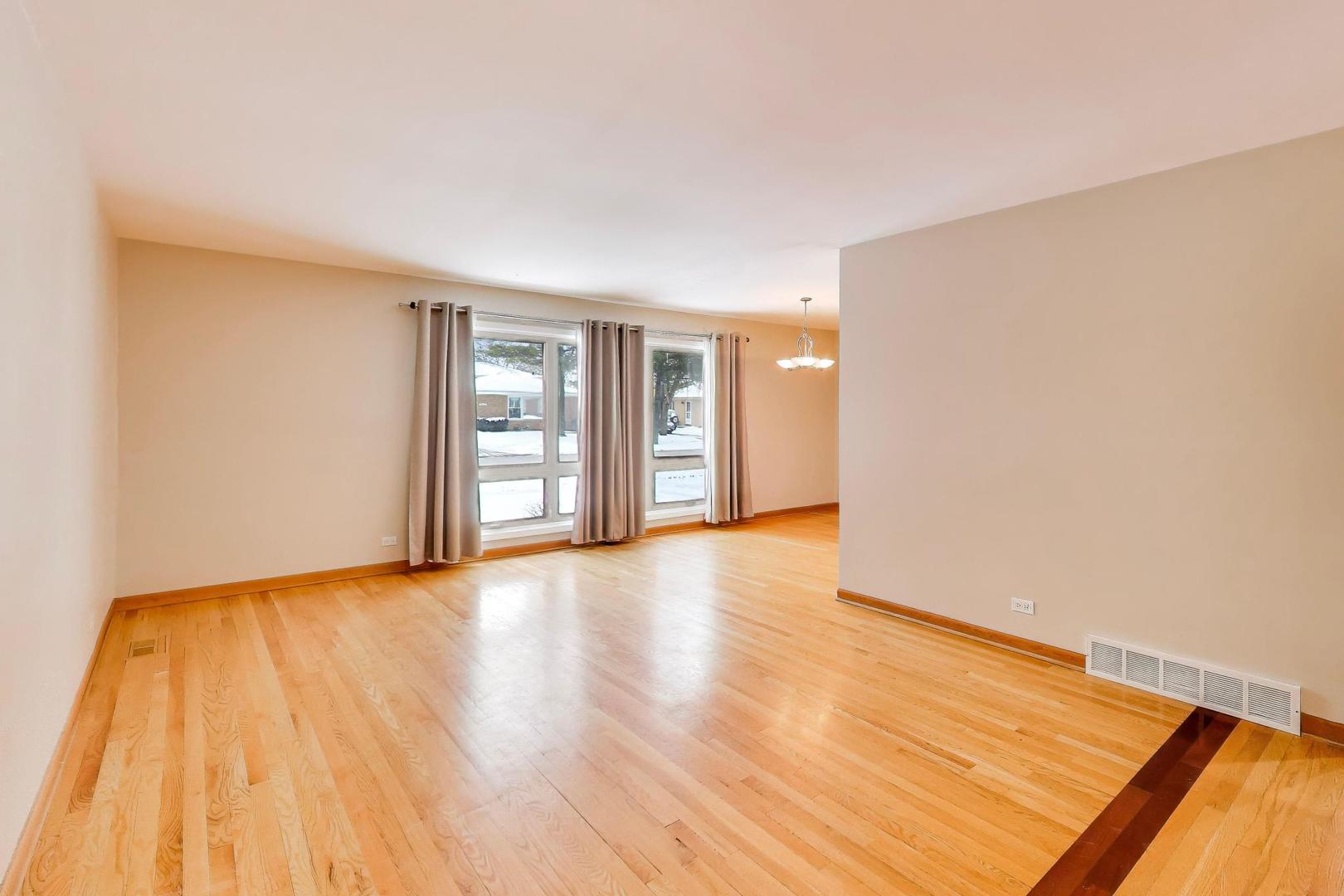 9416 Oliphant Avenue Morton Grove, IL 60053 - Photo 7 of 27 a view of an empty room with wooden floor and a window
