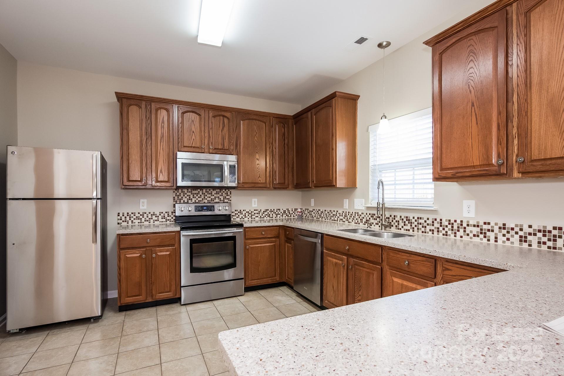 10209 Fairbourne Court Charlotte, NC 28269 - Photo 5 of 15 a kitchen with stainless steel appliances granite countertop a stove a sink dishwasher a refrigerator and a microwave oven