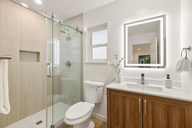 a bathroom with a sink a toilet and shower