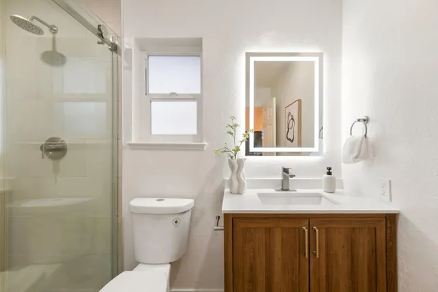 a bathroom with a sink a toilet and shower