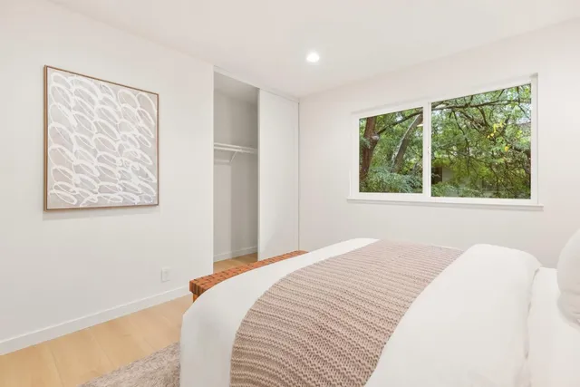 a bedroom with a bed and a large window