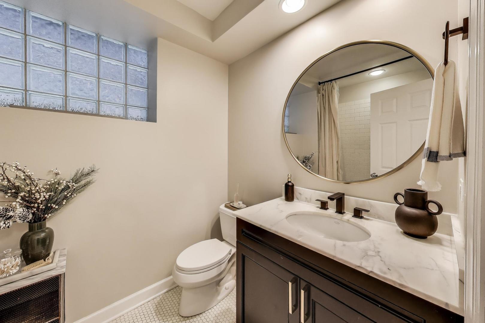 1533 North Cleveland Avenue, Unit 1S Chicago, IL 60610 - Photo 32 of 36 a bathroom with a granite countertop sink a mirror and a toilet