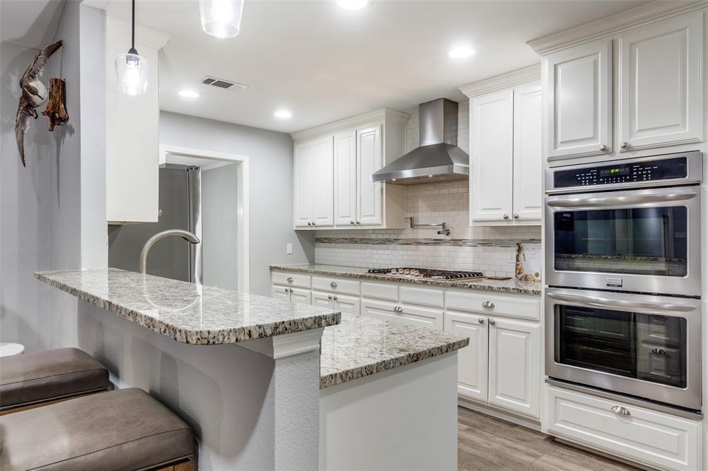 a kitchen with stainless steel appliances granite countertop a stove oven and a white cabinets