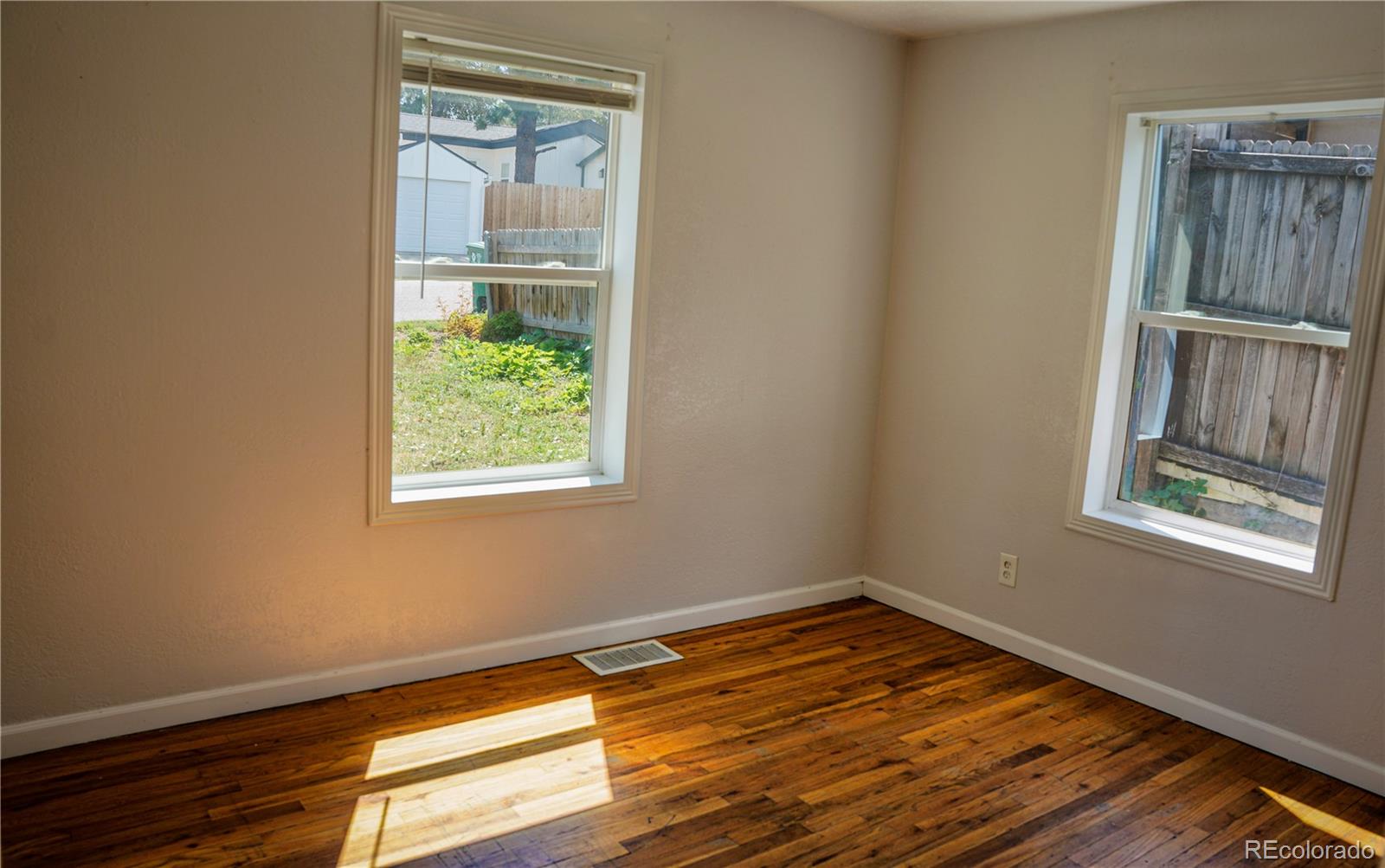 909 Meade Street Denver, CO 80204 - Photo 13 of 15 a view of an empty room with wooden floor and a window