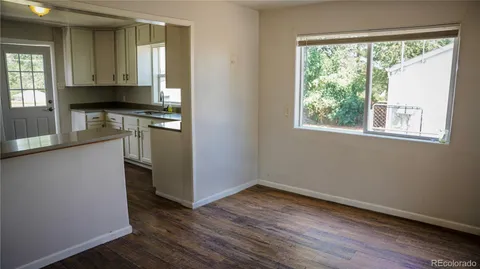 a kitchen with granite countertop white cabinets sink and window