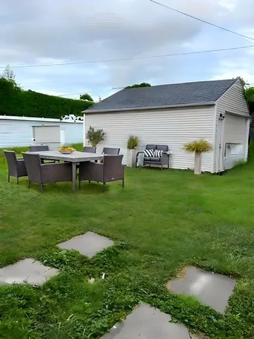 a view of a lake with lawn chairs and large trees