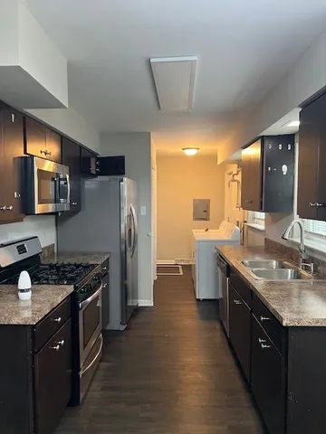 a kitchen with stainless steel appliances granite countertop a sink stove and refrigerator