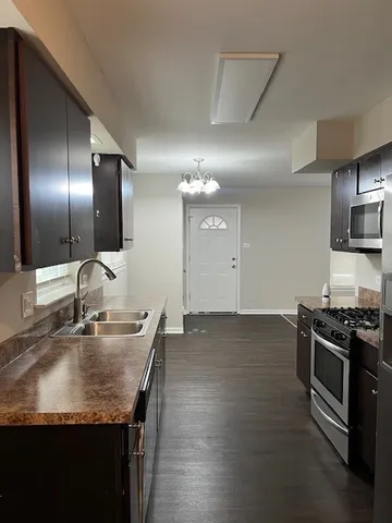 a kitchen with stainless steel appliances granite countertop a sink dishwasher stove and oven with wooden floor