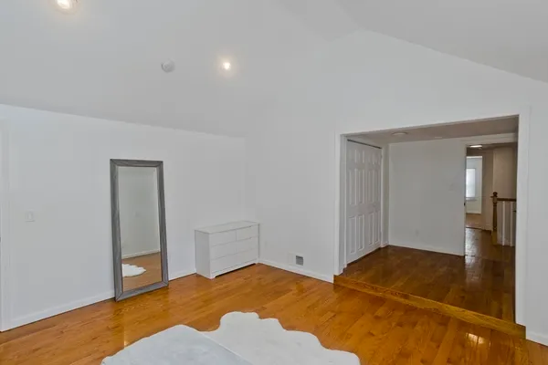 a bedroom with a bed and wooden floor
