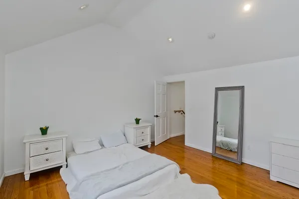 a bedroom with a bed and wooden floor