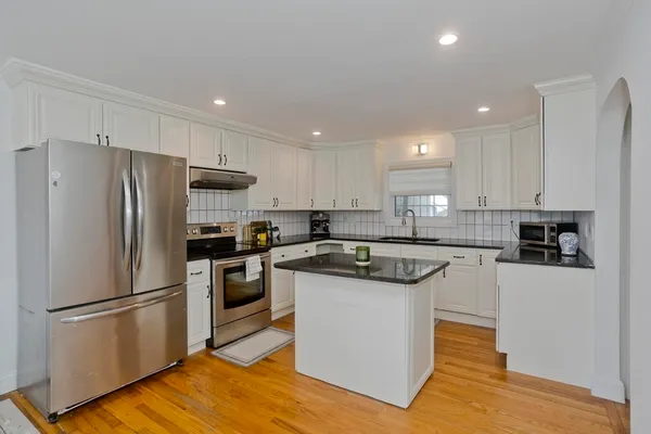 a kitchen with stainless steel appliances granite countertop a refrigerator a stove a sink and a microwave