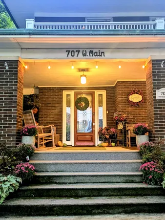 a living room with furniture a flat screen tv and a floor to ceiling window