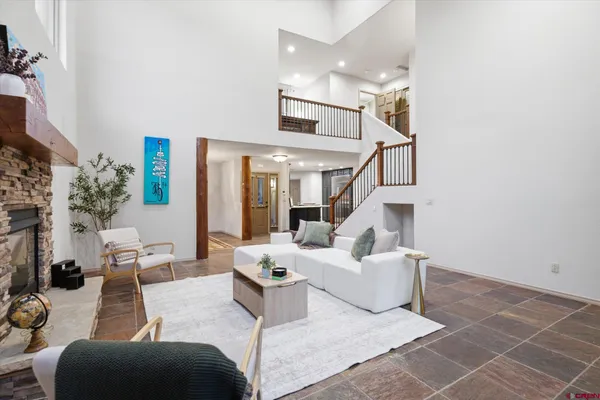 a living room with furniture a fireplace and a chandelier
