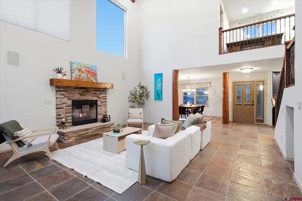 a kitchen with granite countertop a refrigerator a stove and a sink with wooden cabinets