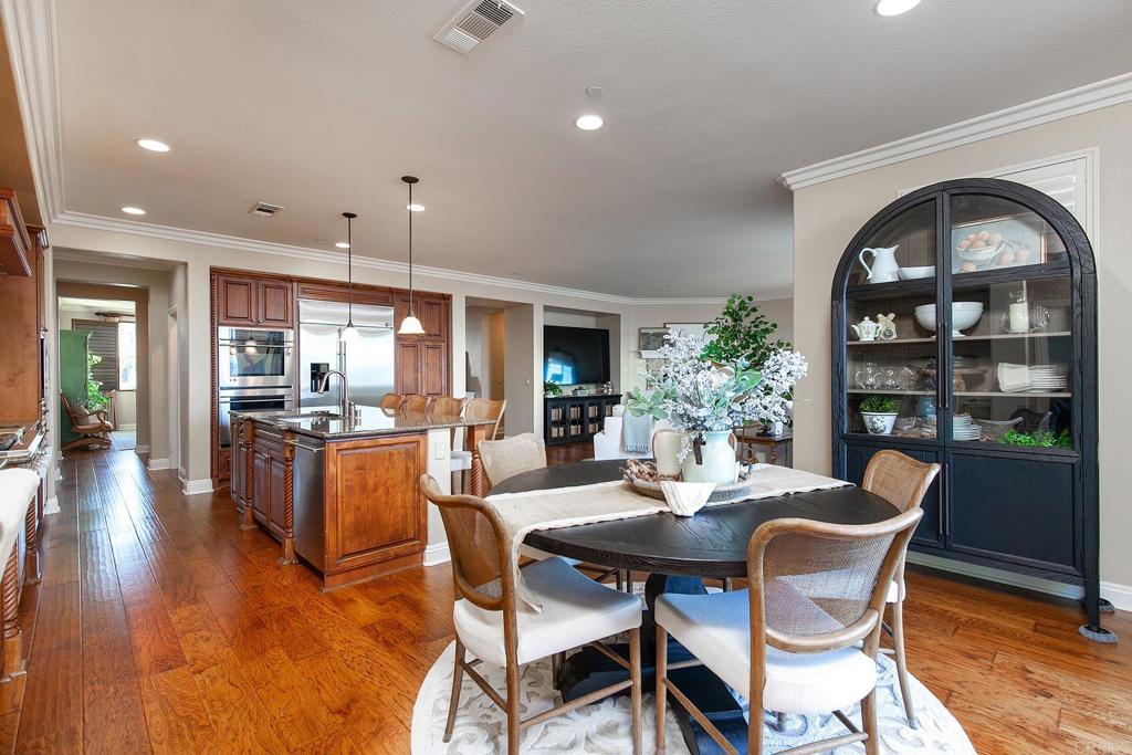7231 Ocotillo Street Santee, CA 92071 - Photo 16 of 59 a dining room with furniture a kitchen and chandelier