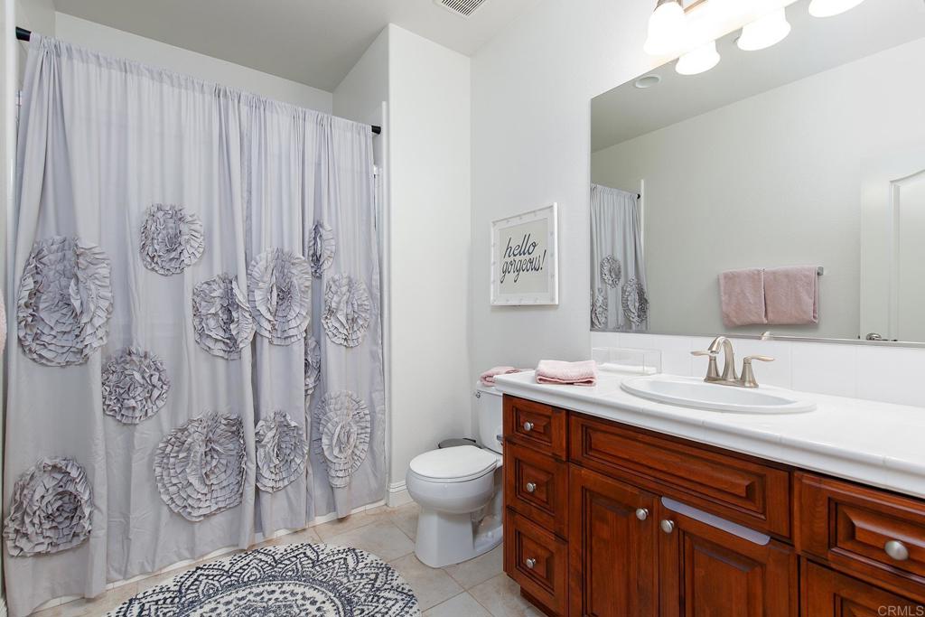 7231 Ocotillo Street Santee, CA 92071 - Photo 28 of 59 a bathroom with a granite countertop toilet sink and mirror