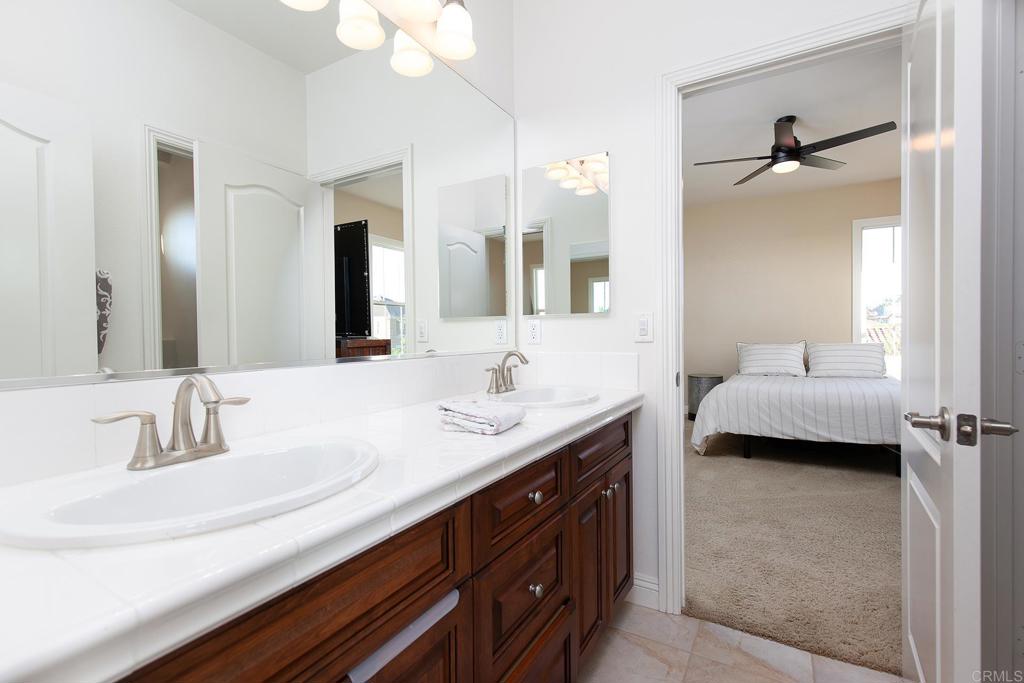 7231 Ocotillo Street Santee, CA 92071 - Photo 34 of 59 a en suite bathroom with a double vanity sink and a mirror