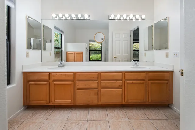 a bathroom with a granite countertop sink and a mirror