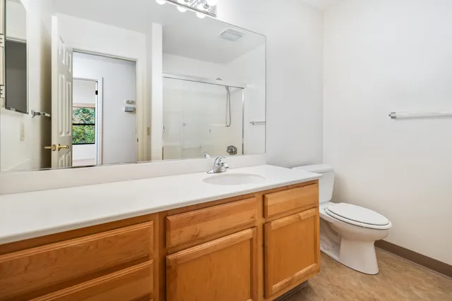 a bathroom with a sink a toilet and a mirror