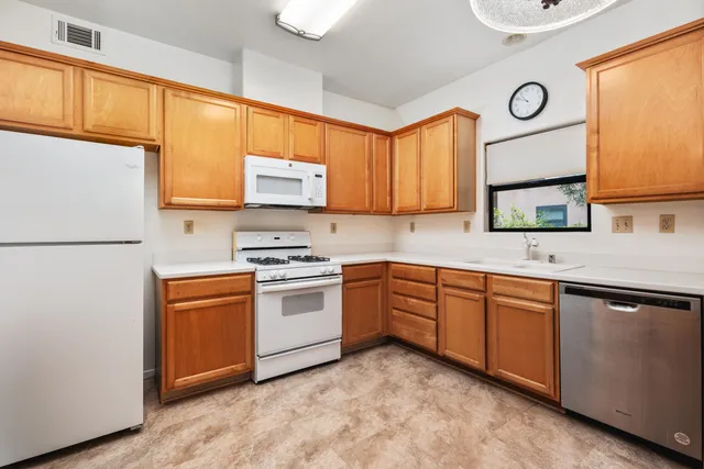 a kitchen with stainless steel appliances granite countertop a stove a sink and a refrigerator
