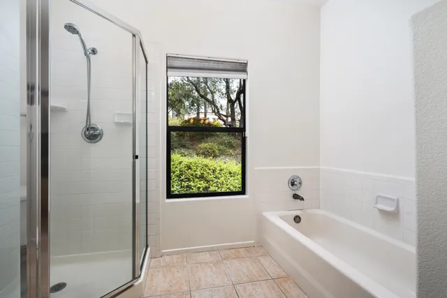 a bathroom with a tub shower and toilet