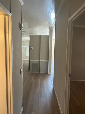 a view of a hallway with wooden floor