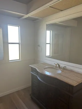 a bathroom with a granite countertop sink and a mirror