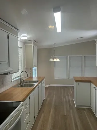a kitchen with kitchen island a sink appliances and cabinets